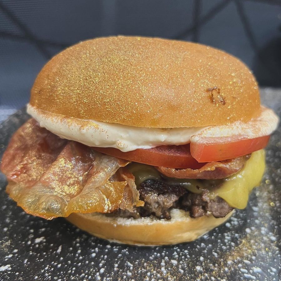 Hamburguesa con bacon crujiente, queso fundido, tomate y salsa